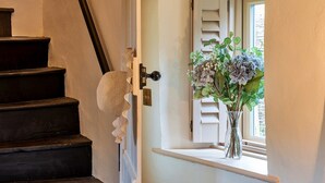 A staircase with a textured wall and a window with shutters. - Cottage in Dorset near Lulworth Cove (Winterborne Houghton)
