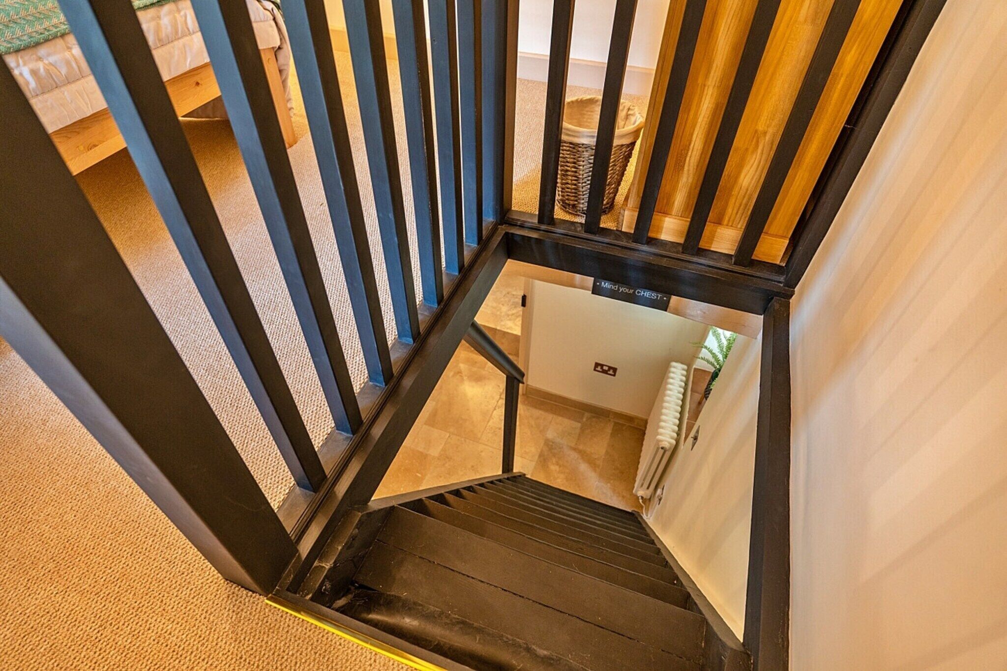 A staircase with black metal railings and a handrail, leading to a lower level.