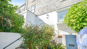 A residential building with a blue door labeled "Hillside House," surrounded by lush greenery and a white wall. - Holiday Home in Kingsand near the Beach (Kingsand)