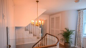 A staircase with white railings and a chandelier. - Holiday Home in Kingsand near the Beach (Kingsand)