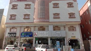 A multi-story building with several ground-floor shops, including a car dealership and a furniture store.