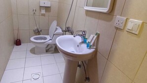 A small bathroom with a toilet, sink, and shower.