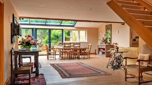 A spacious living area with a dining table, chairs, a sofa, and a staircase. - Villa in Pollença with Sea Views & Pool (Kingham)