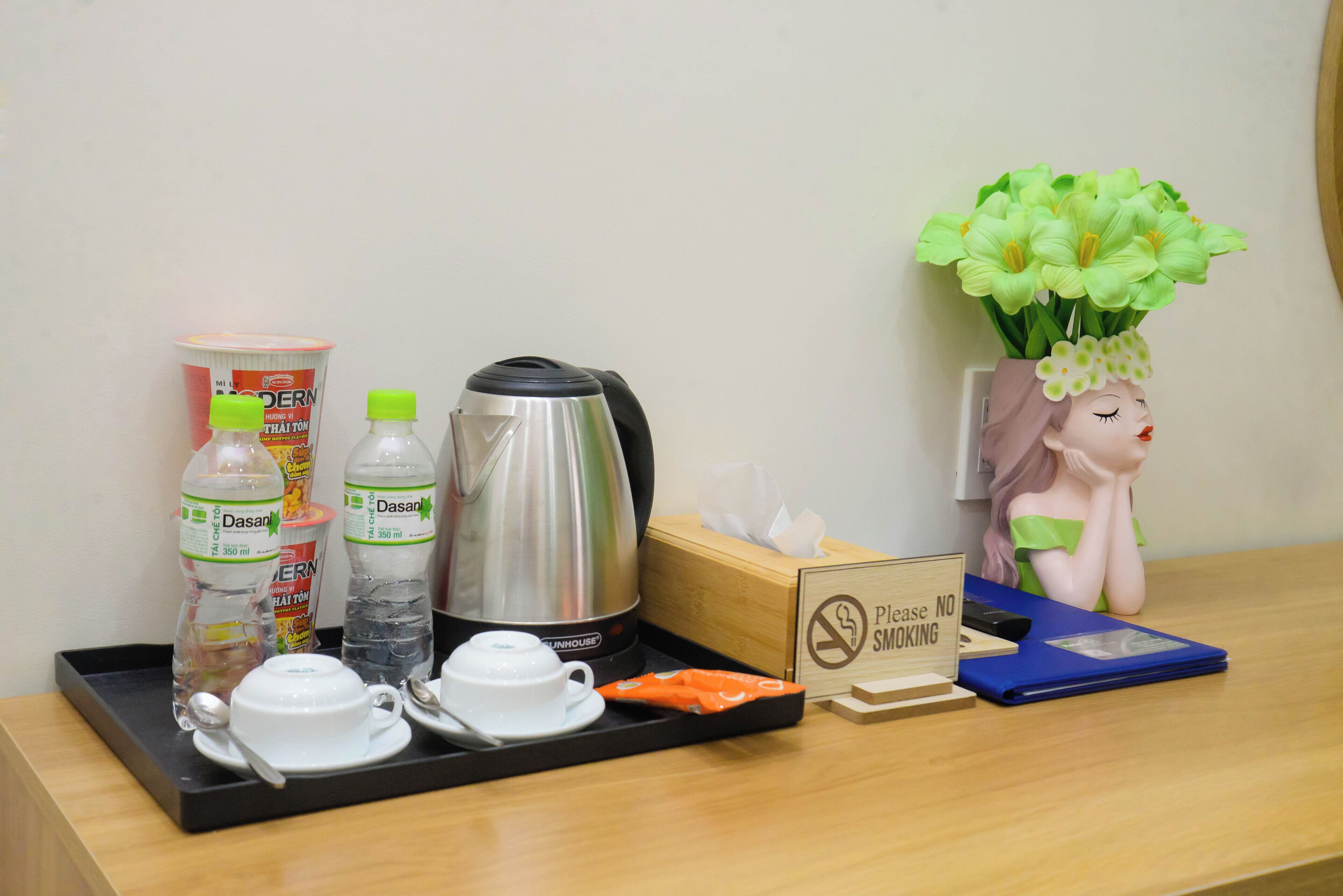 A hotel room's breakfast trolley with a coffee maker, tea, condiments, and a no-smoking sign.