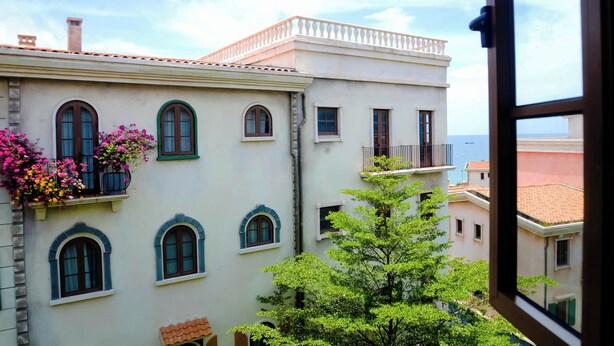 A building with multiple windows and balconies, some with flowers. - Tina's House & Spa (Phu Quoc)