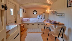 Une chambre confortable avec un lit, une table de chevet et un petit bureau avec une chaise.