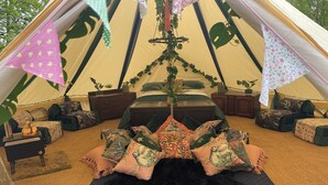 A tent with a bed, pillows, and a hanging plant. - Cottage for 6 guests in Woolton Hill. (Woolton Hill)