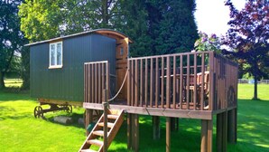 A wooden deck with a staircase leading to a small cabin-like structure. - Shepherd's Hut in Romsey with Fire Pit (Romsey)