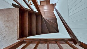 A wooden staircase with a carpeted landing and a white door at the top. - Cottage by Loch with Stunning Views (Achahoish)