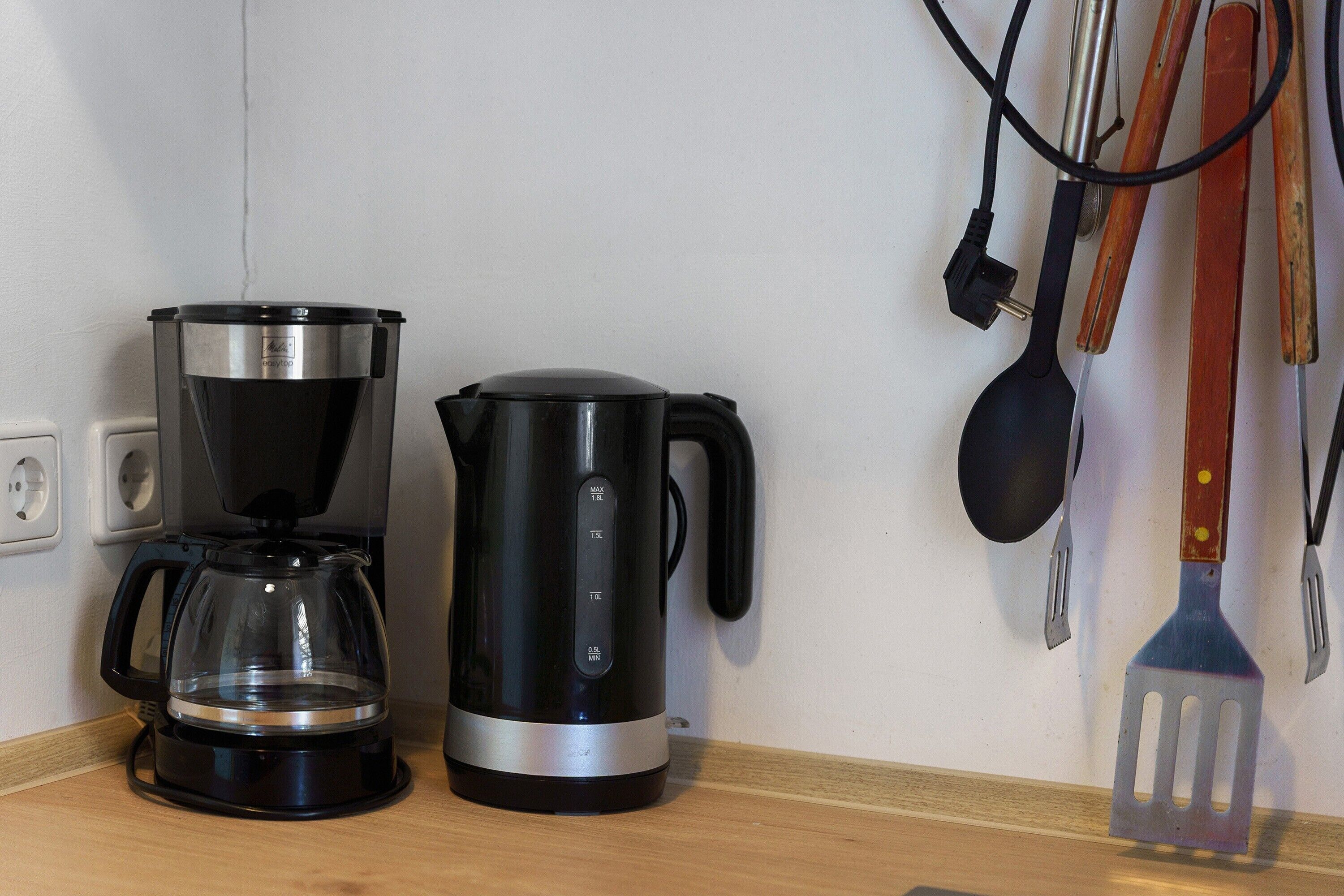 A coffee maker and a kettle on a kitchen counter.