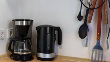 A coffee maker and a kettle on a kitchen counter.