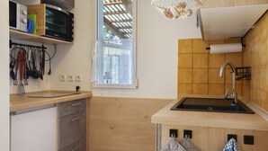 Eine Küche mit Holzausstattung, einer eingebauten Mikrowelle, einem Spülbecken und einem Fenster mit Blick.