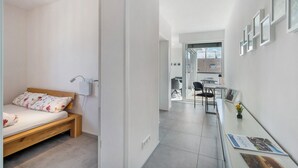 Un dormitorio moderno con una cama de madera, una mesita de noche y un escritorio con silla.