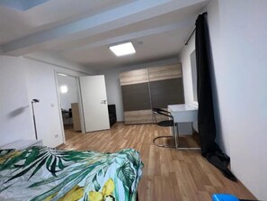Un dormitorio con una cama, un escritorio y un armario.