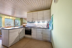 A kitchen with light wood cabinets, a stainless steel oven, and a tiled backsplash. - Apartment 'Fluss Aufwärts' with Private Terrace and Wi-Fi (Schülp)