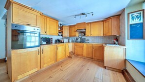 A kitchen with wooden cabinets, a stainless steel oven, and a tiled backsplash.