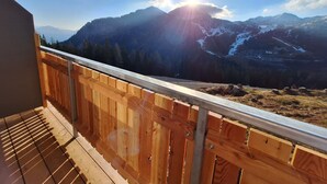 A wooden balcony with a view of a mountainous landscape. - Apartment '1' with Mountain View, Shared Garden and Wi-Fi (Sonnenalpe Nassfeld)