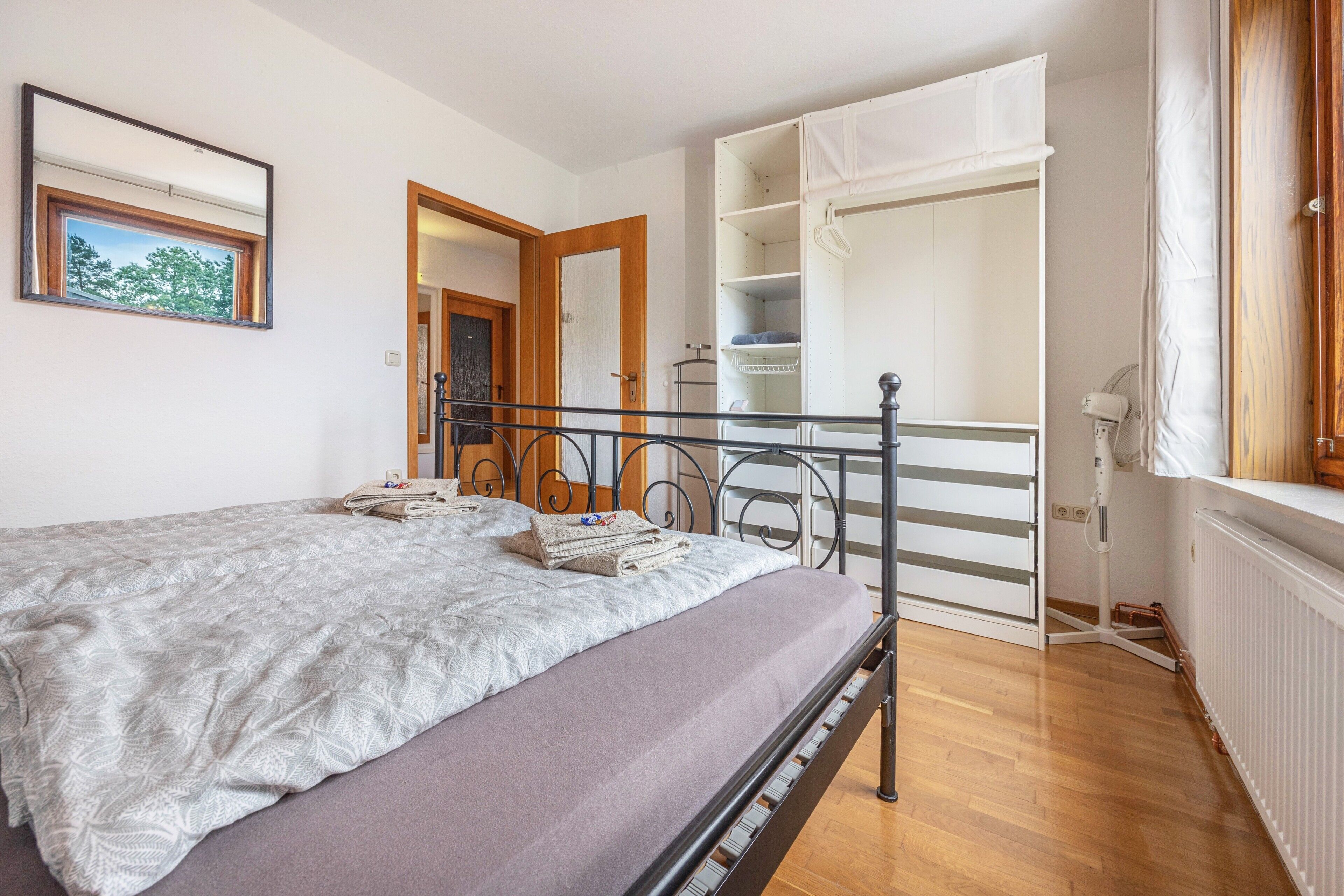 Una camera da letto con un letto, un armadio, un termosifone e una finestra.