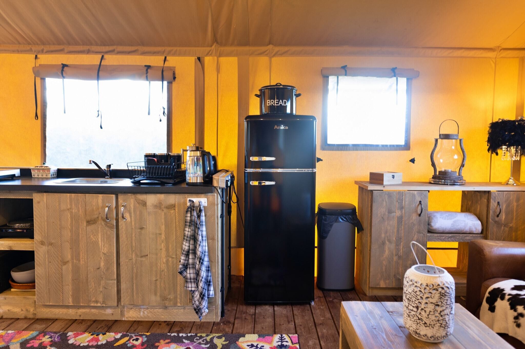 A compact kitchen with wooden cabinets, a black refrigerator, and a small countertop.