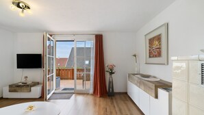 A modern kitchen with a wooden countertop, a built-in oven, and a large window. - Apartment 'Weinberg' with Balcony (Meersburg)