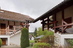 A traditional building with a tiled roof, wooden staircase, and a well-maintained garden. - Holiday Apartment 'Am Bärenhof' with Mountain View, Sauna, Balcony and Wi-Fi (Titisee-Neustadt)