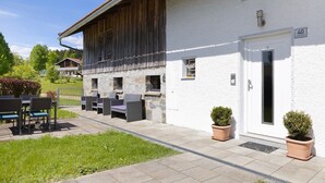 A building with a stone facade, a wooden extension, outdoor seating, and a door marked with the number 40. - Holiday Home 'Ferienhaus Kreuzbergblick' with Mountain View, Private Terrace and Wi-Fi (Hohenau)