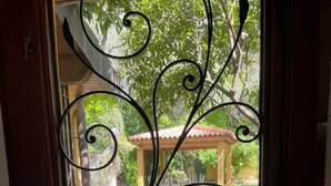 A door with a decorative metal screen featuring a garden view.