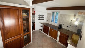 A kitchen with wooden cabinets, a built-in oven, and a window with frosted glass.