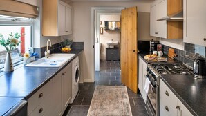 A modern kitchen with a built-in washing machine, a stove, and a sink.