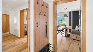 A modern interior with wooden flooring, a dining area with a table and chairs, and a seating area with a sofa. - Holderstanzenhof: Apartment 'Talblick' with Mountain View, Private Balcony and Wi-Fi (Bad Peterstal-Griesbach)