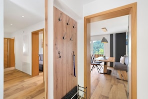 Un intérieur moderne avec un plancher en bois, un coin repas comprenant une table et des chaises, et un espace détente avec un canapé.