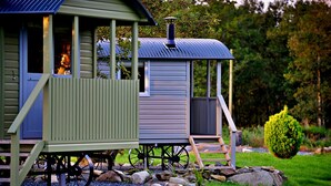 A rustic cabin with a chimney, a porch, and a small deck. - Shepherd's Hut on Llŷn Peninsula, Near Snowdonia (Pwllheli)