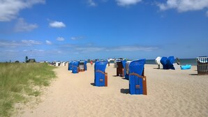 A beach with rows of blue beach huts numbered 9 and 12, a sandy path, and the ocean in the background. - Holiday Apartment 'Maltes' with Sea View, Private Terrace and Wi-Fi (Kappeln)
