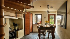 Un comedor con una mesa de madera, sillas y una chimenea.
