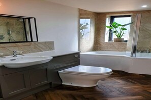 Un baño moderno con lavamanos, inodoro y bañera.