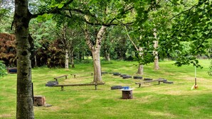 A circular arrangement of tires and benches in a grassy park area with trees. - Bell Tent in Devon with Countryside Views (Ilfracombe)