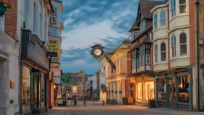 A street with historic buildings, a clock, and a sign that says "SHOP LET". - Woodland Pod near Highclere Castle (Woolton Hill)