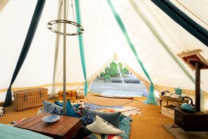 Relax in a comfortable seating area with a portable stove for cooking and a hanging light fixture.