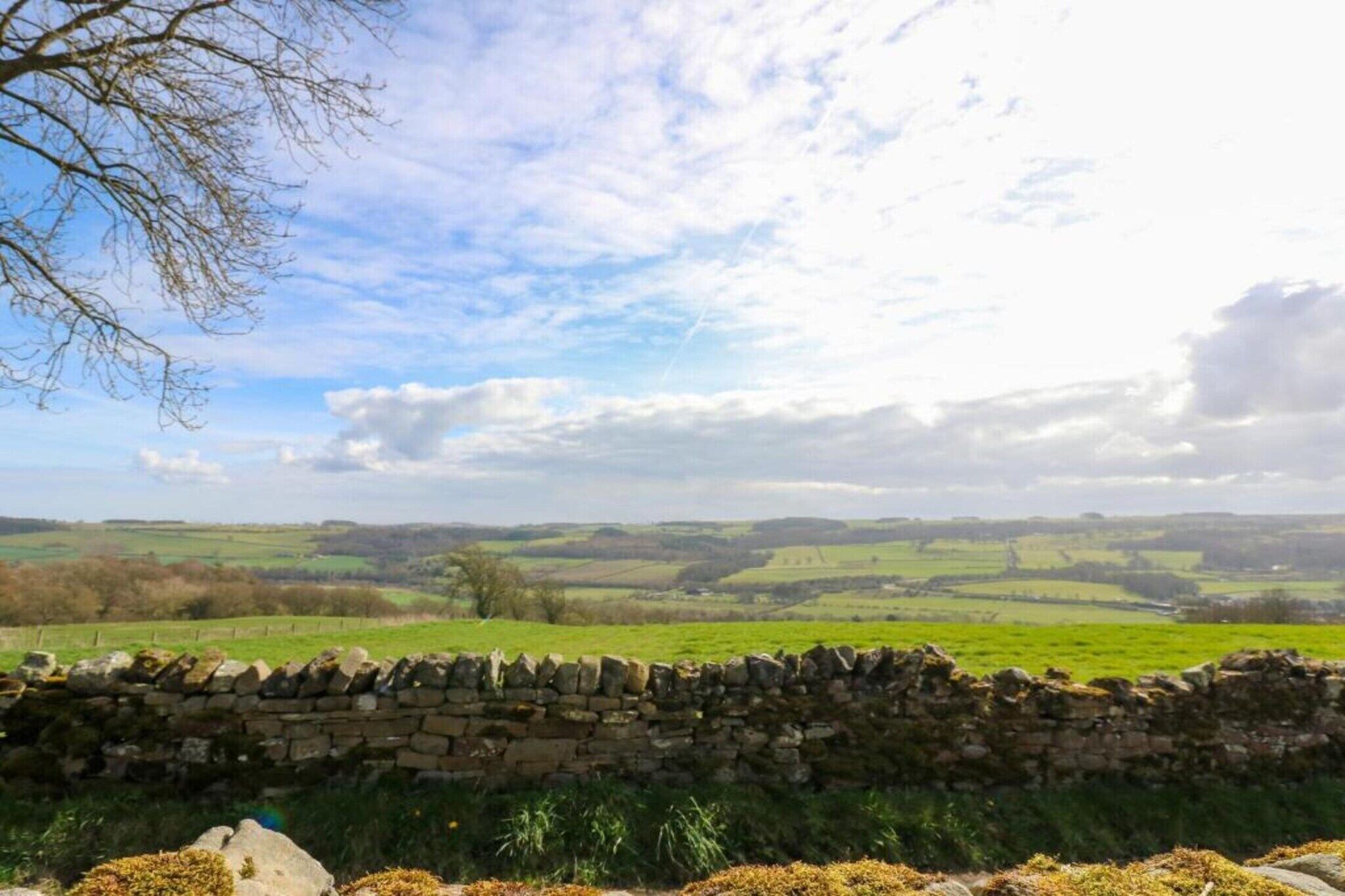 A stone wall with a stone fence in a rural landscape.