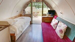 Una habitación acogedora y compacta con cama, un escritorio pequeño y televisión.