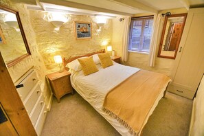 A bedroom with a bed, nightstands, a dresser, a mirror, and a window with curtains. - Cottage in Kingsand with Stunning Sea Views (Kingsand)
