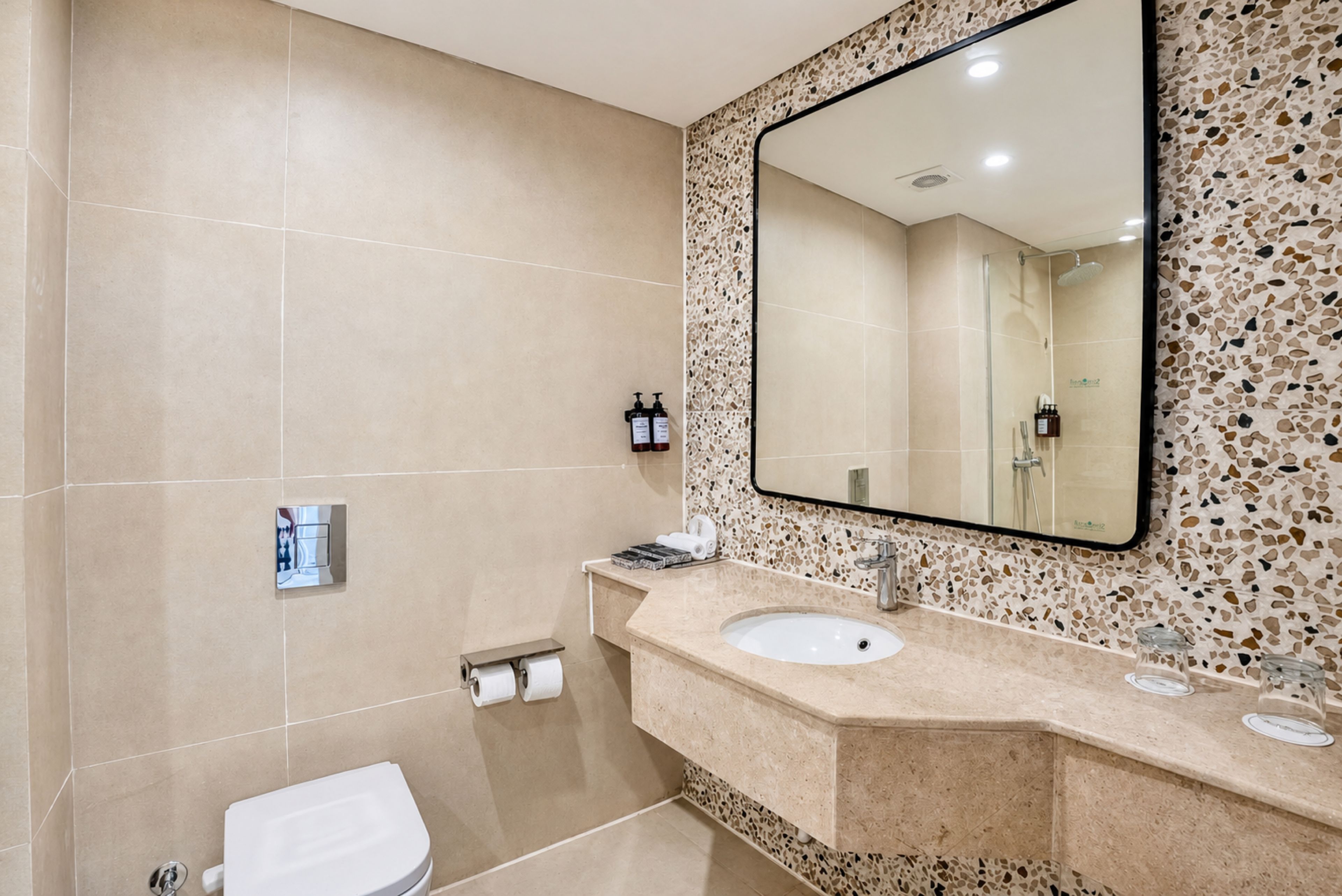 Un baño con inodoro, lavabo y espejo.
