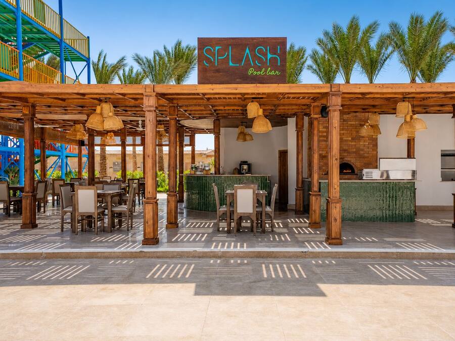 An outdoor pool bar area with wooden pergolas, tables, and chairs.