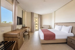 Una habitación de hotel con cama, escritorio, silla y ventana.