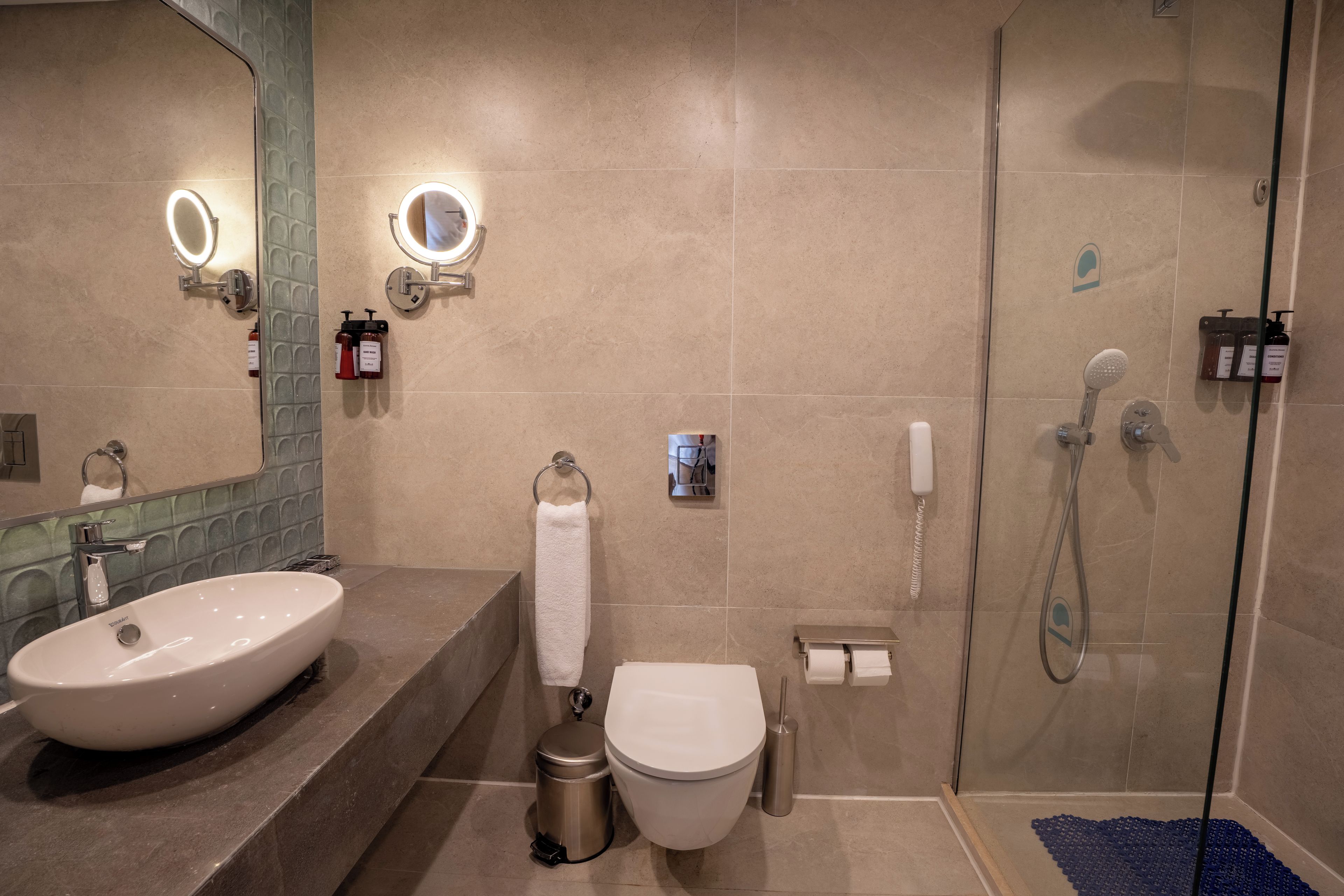 A modern bathroom with a large sink, toilet, and shower.