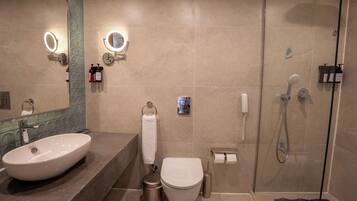 A modern bathroom with a large sink, toilet, and shower.