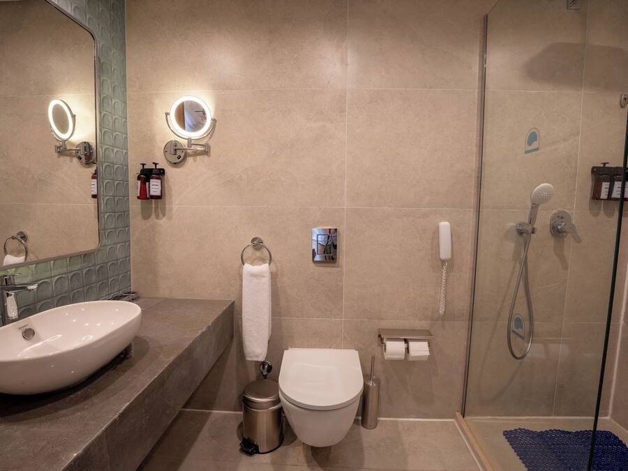 A modern bathroom with a large sink, toilet, and shower.