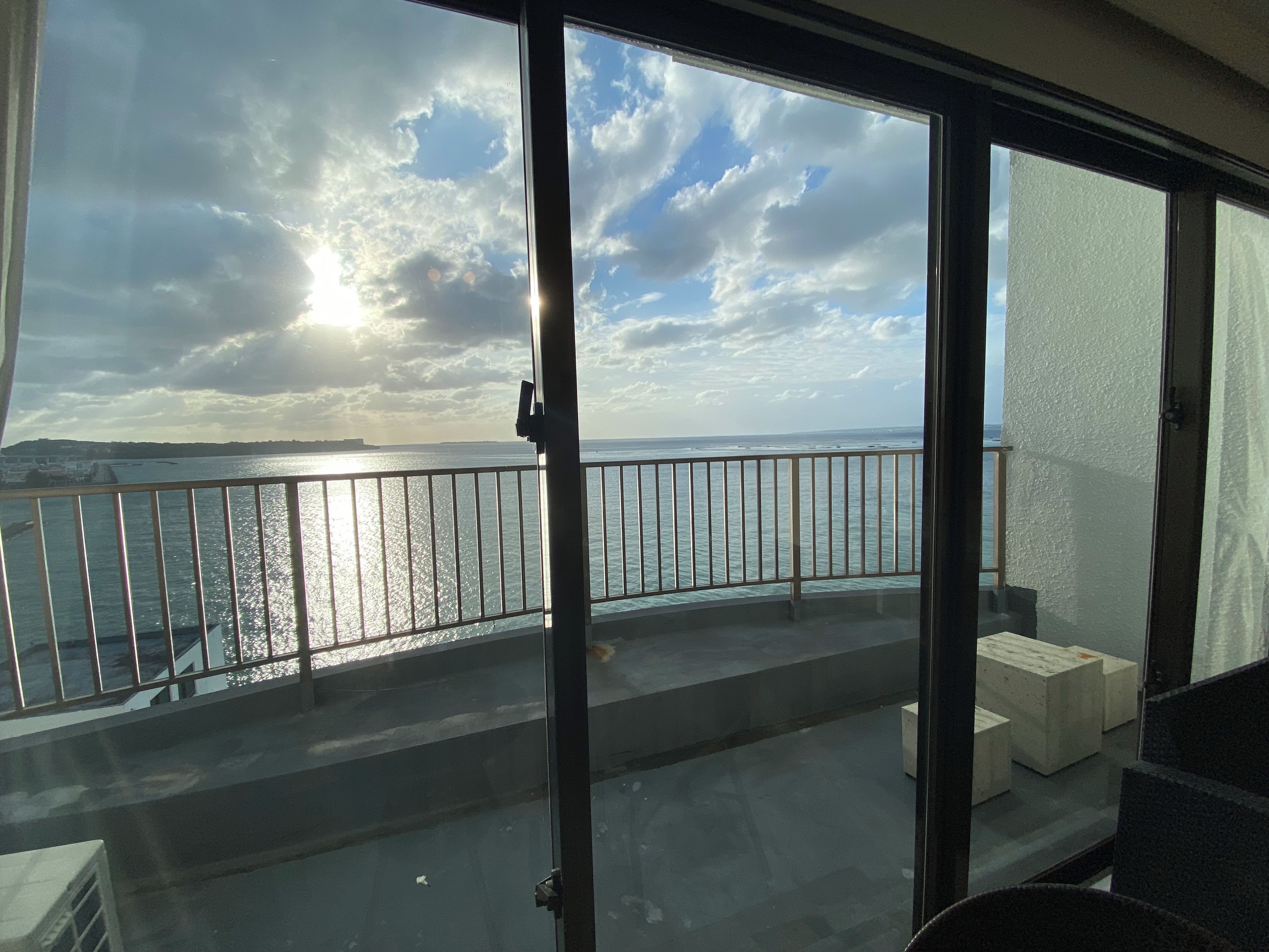 A balcony with a view of the sea and a cloudy sky.
