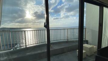 A balcony with a view of the sea and a cloudy sky.