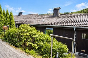 A building with a tiled roof, a chimney, and a number '31' on the side.
